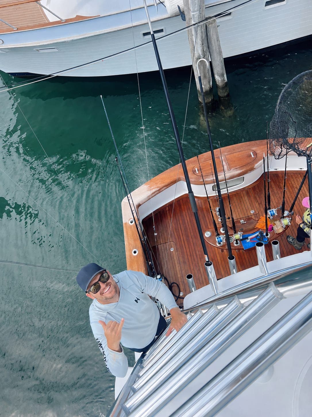 An overhead view of Garreth on the bow of a sportfishing boat at a jetty.