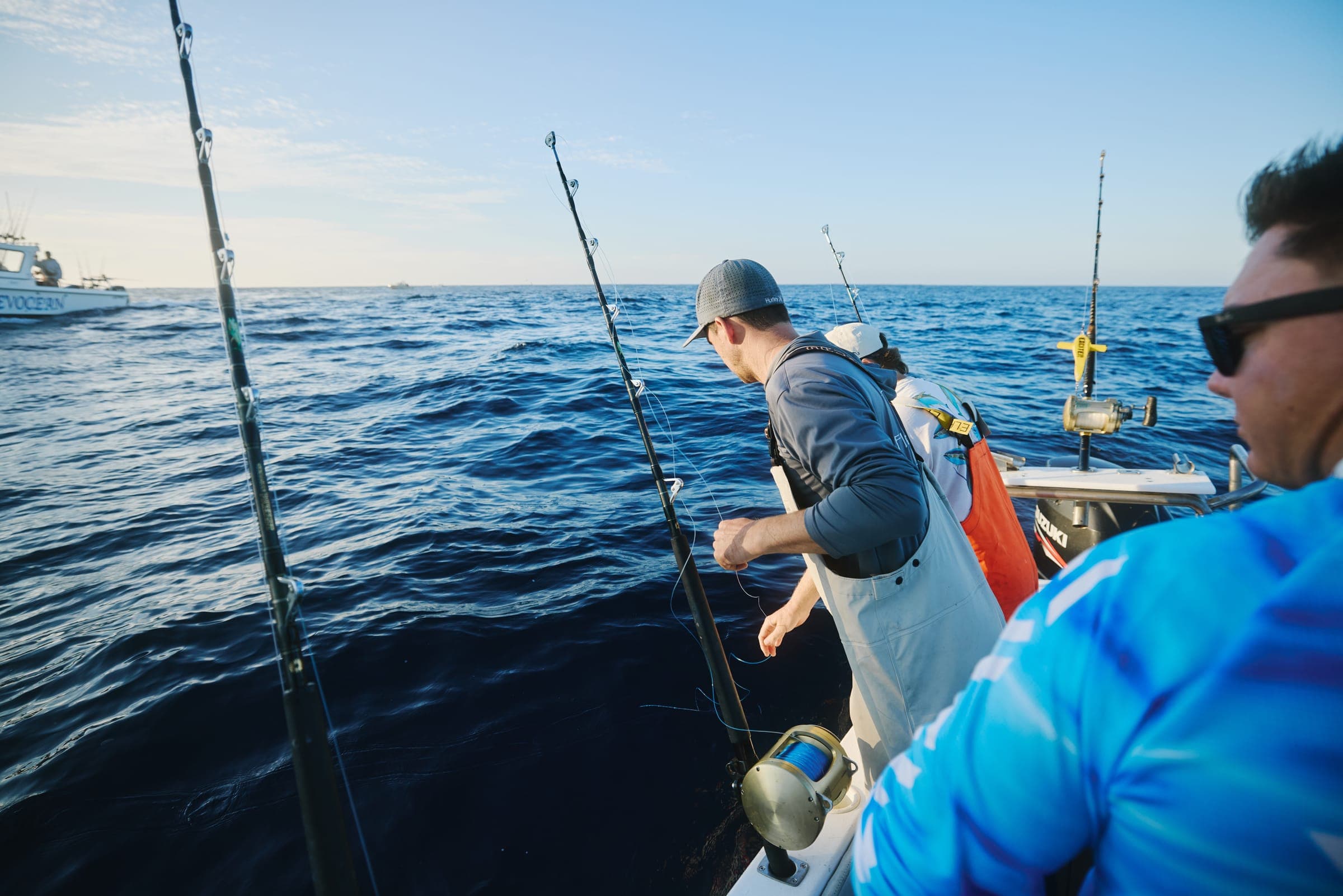 Two anglers watching a spread of trolling rods from the deck of Benguela on deep blue water offshore of Cape Point.